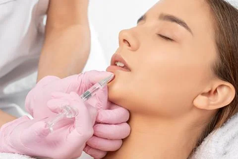 Cosmetologist does injections for lips augmentation and anti wrinkle in the n Stock Photos