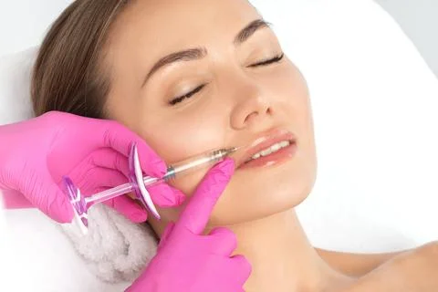 Cosmetologist does injections for lips augmentation and anti wrinkle in the n Stock Photos