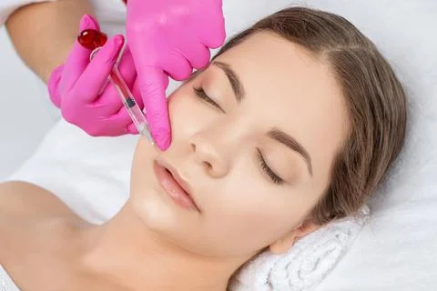 Cosmetologist does injections for lips augmentation and anti wrinkle in the n Stock Photos