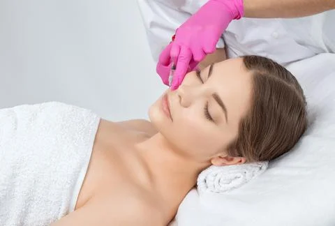 Cosmetologist does injections for lips augmentation and anti wrinkle in the n Stock Photos