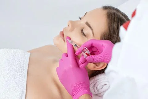 Cosmetologist does injections for lips augmentation and anti wrinkle in the n Stock Photos