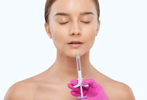 Cosmetologist does injections for lips augmentation and anti wrinkle in the n Stock Photos
