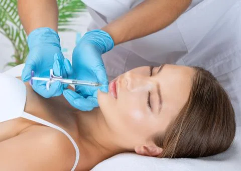 Cosmetologist does injections for lips augmentation and anti wrinkle in the n Stock Photos