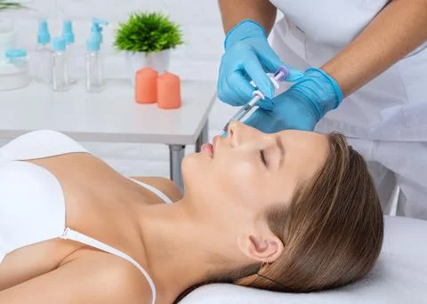 Cosmetologist does injections for lips augmentation and anti wrinkle in the n Stock Photos