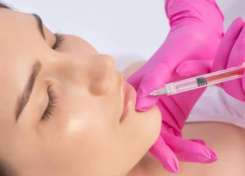 Cosmetologist does injections for lips augmentation and anti wrinkle in the n Stock Photos