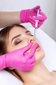 Cosmetologist does injections for lips augmentation and anti wrinkle in the n Stock Photos