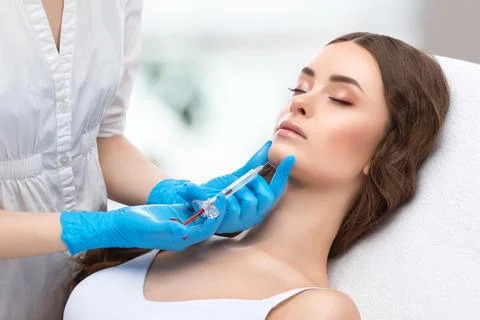 Cosmetologist does injections for lips augmentation and anti wrinkle in the.. Stock Photos