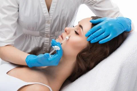 Cosmetologist does injections for lips augmentation and anti wrinkle in the.. Stock Photos