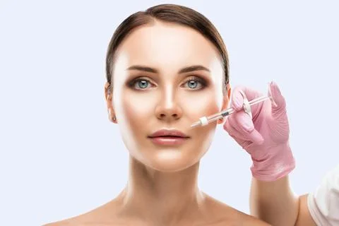 Cosmetologist does injections for lips augmentation and anti wrinkle in the.. Stock Photos