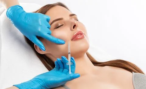 Cosmetologist does injections for lips augmentation and anti wrinkle inject.. Stock Photos
