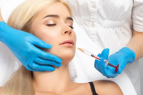 Cosmetologist does injections for lips augmentation and anti wrinkle in the.. Foto stock