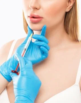Cosmetologist does injections for lips augmentation and anti wrinkle in the.. Stock Photos