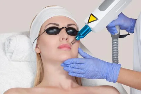 Cosmetologist does the procedure of permanent makeup removal from the lips an Stock Photos