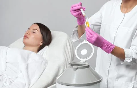 Cosmetologist does prp therapy on the face of a beautiful woman in a beauty s Stock Photos