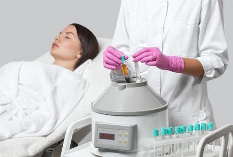Cosmetologist does prp therapy on the face of a beautiful woman in a beauty s Stock Photos