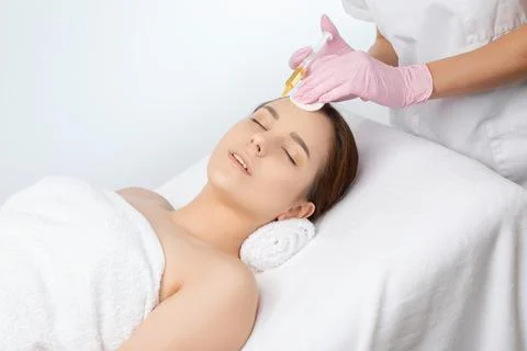 Cosmetologist does prp therapy on the face of a beautiful woman in a beauty s Foto stock