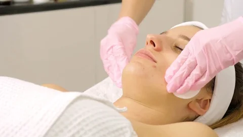 Cosmetologist is doing Face peeling mask, spa beauty treatment for young girl. Stock Footage 84178975