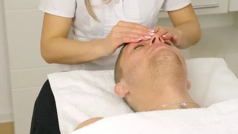 Cosmetologist is doing procedure of face massage for young boy / man. Stock Footage 84179860