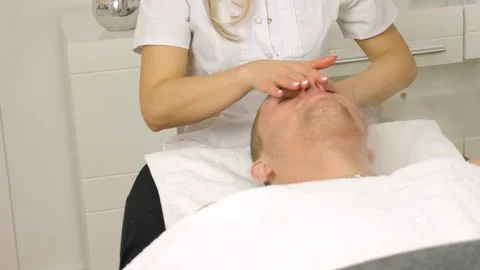 Cosmetologist is doing procedure of face massage for young boy / man. Stock Footage 84179942