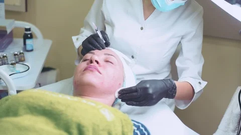 Cosmetologist in gloves making face injection in a female skin Stock Footage 95984137
