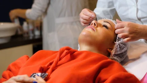 Cosmetologist is going face mask . peeling for young woman. Woman is having Stock Footage 86571783
