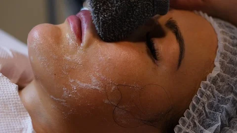 Cosmetologist is going face mask . peeling for young woman. Woman is having Stock Footage 86572767