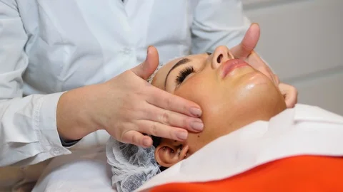 Cosmetologist is going face mask . peeling for young woman. Woman is having Stock Footage 86597280