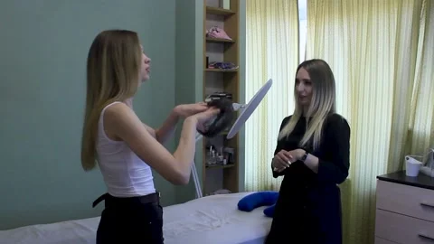 Cosmetologist greets a client. Client puts on disposable cap. Consultation Stock Footage 150399194