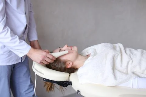 Cosmetologist guy makes special face massage to girl with cosmet 스톡 사진