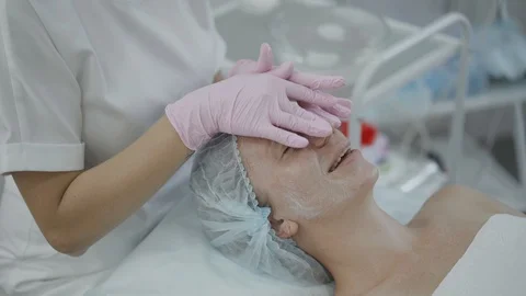 Cosmetologist make a scrub the face of the patient Stock Footage 102464232