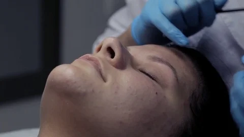 Cosmetologist makes eyebrow correction to client Stock Footage 81671604