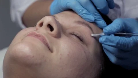 Cosmetologist makes eyebrow correction to client Stock Footage 81671700
