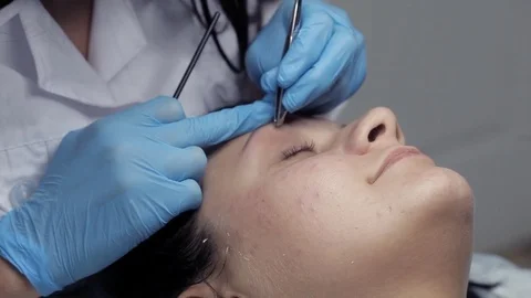 Cosmetologist makes eyebrow correction to client Stock Footage 81672335