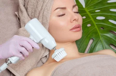 The cosmetologist makes the Hardware face cleaning  procedure with a soft rot Stock Photos
