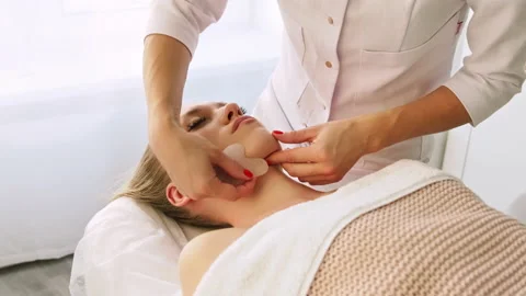 Cosmetologist makes lifting modeling face massage Gua Sha scraper Stock Footage 169537338