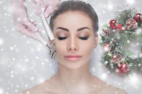 The cosmetologist makes the Microcurrent therapy procedure of a beautiful wom Stock Photos