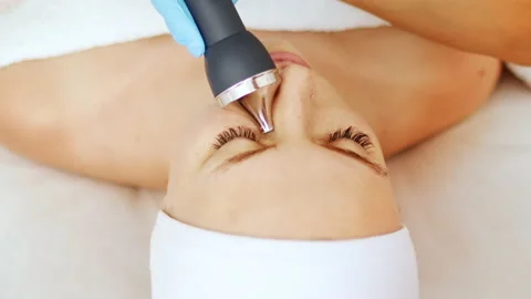 Cosmetologist makes a procedure on the face with microcurrent therapy Stock Footage 238753281
