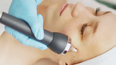 Cosmetologist makes a procedure on the face with microcurrent therapy Stock Footage 242027682