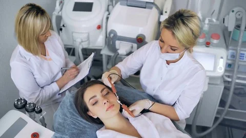 Cosmetologist makes the procedure microcurrent therapy of the facial skin of a 스톡 동영상 83283229
