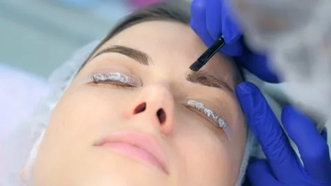 Cosmetologist making lash laminating and eyebrow painting for woman in clinic. Stock-Footage 136874218