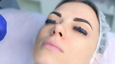 Cosmetologist making lash laminating, eyebrow and lash painting for woman. Stock Footage 136874520