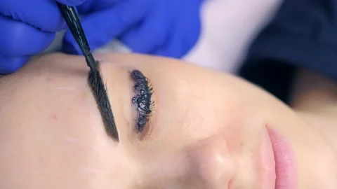 Cosmetologist making lash laminating, eyebrow and lash painting for woman. Stock Footage 136874645