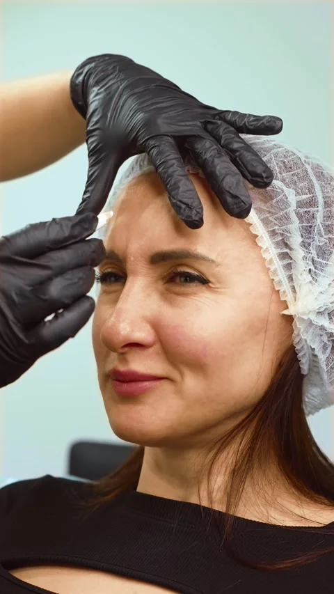 Cosmetologist making marks on face to indicate problem areas and injection Stock Footage 311572688