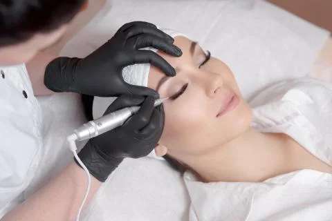 Cosmetologist making permanent makeup Stock Photos