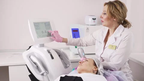 The cosmetologist manually adjusts the devices on the screen for the laser hair Stock Footage 270398775