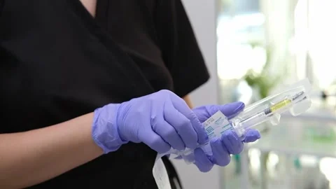 The cosmetologist is performing a rejuvenating injection procedure, taking out Stock Footage 318913341