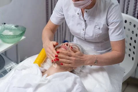 Cosmetologist performs facial skin cleansing procedure Stock Photos
