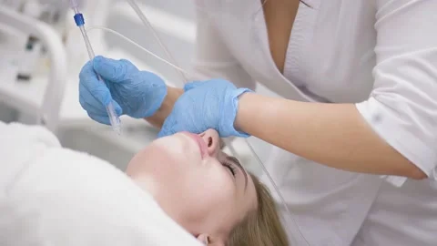 Cosmetologist performs a gas-liquid peeling procedure - rejuvenation and Stock-Footage 230183193