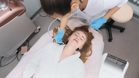 Cosmetologist performs a gas-liquid peeling procedure - rejuvenation and Stock-Footage 230183219