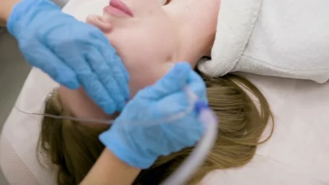Cosmetologist performs a gas-liquid peeling procedure - rejuvenation and Stock-Footage 231073104